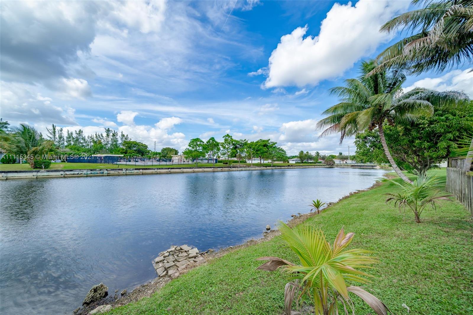 7921 Northwest 90th Avenue Tamarac, FL 33321 - Photo 56 of 69 a view of a lake with a big yard and potted plants