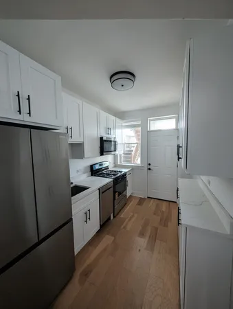 a kitchen with granite countertop a refrigerator and a sink