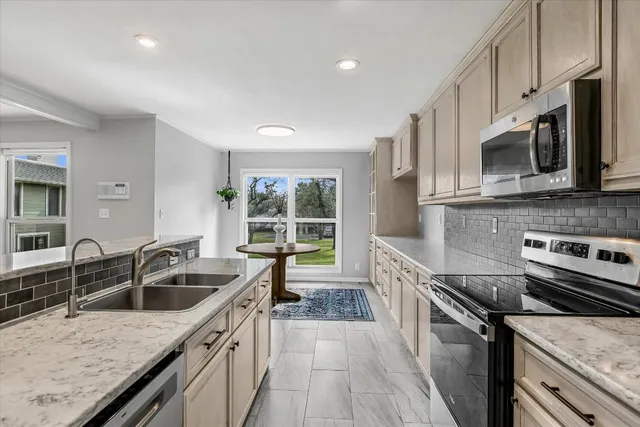 a kitchen with a sink stove top oven and refrigerator
