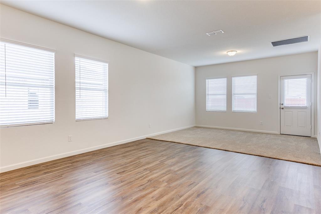 1816 Wolf Run Anna, TX 75409 - Photo 7 of 11 an empty room with wooden floor and windows