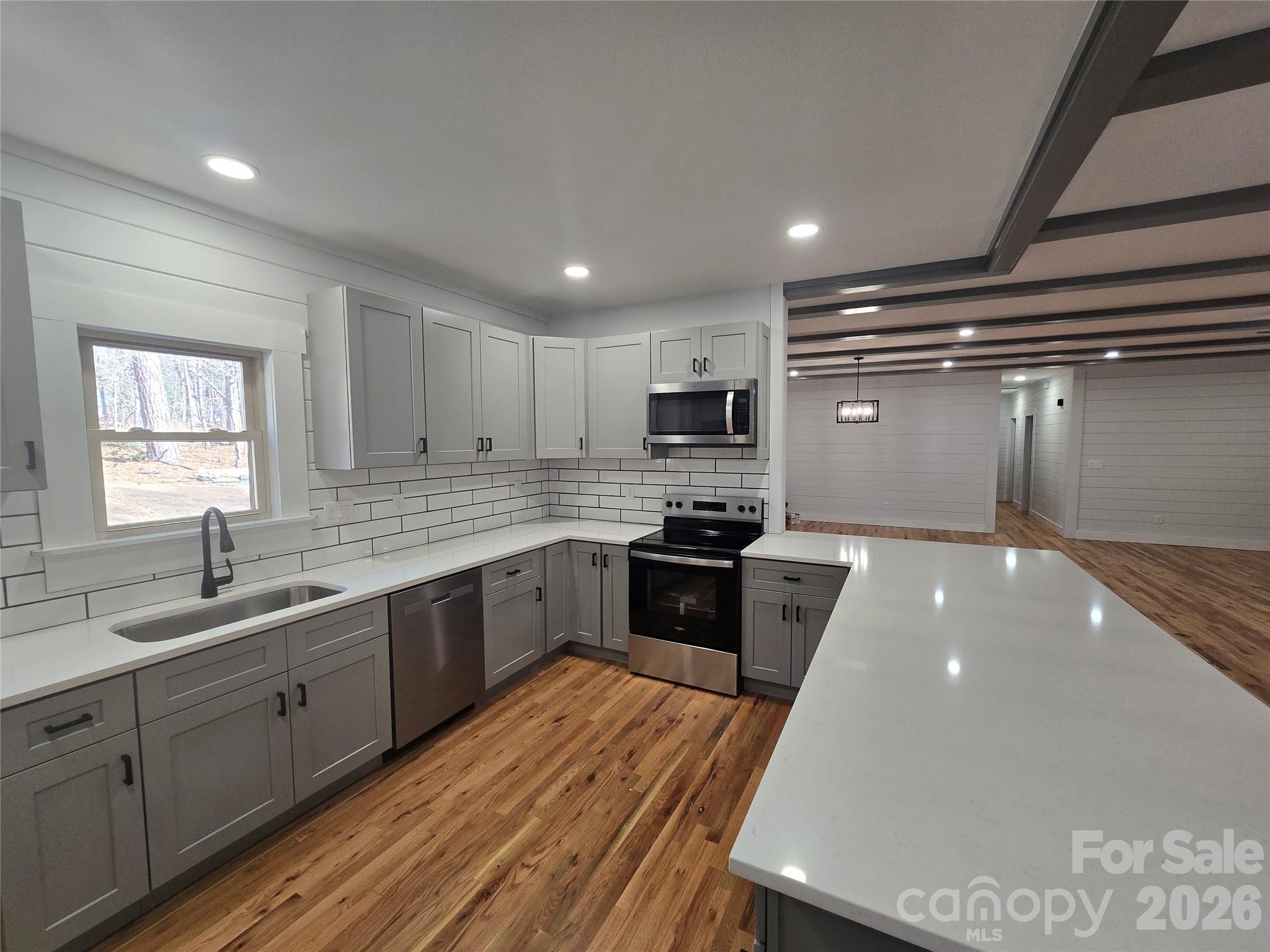 6802 Lowesville Lane Stanley, NC 28164 - Photo 13 of 25 a large kitchen with a large counter top a sink stainless steel appliances and cabinets