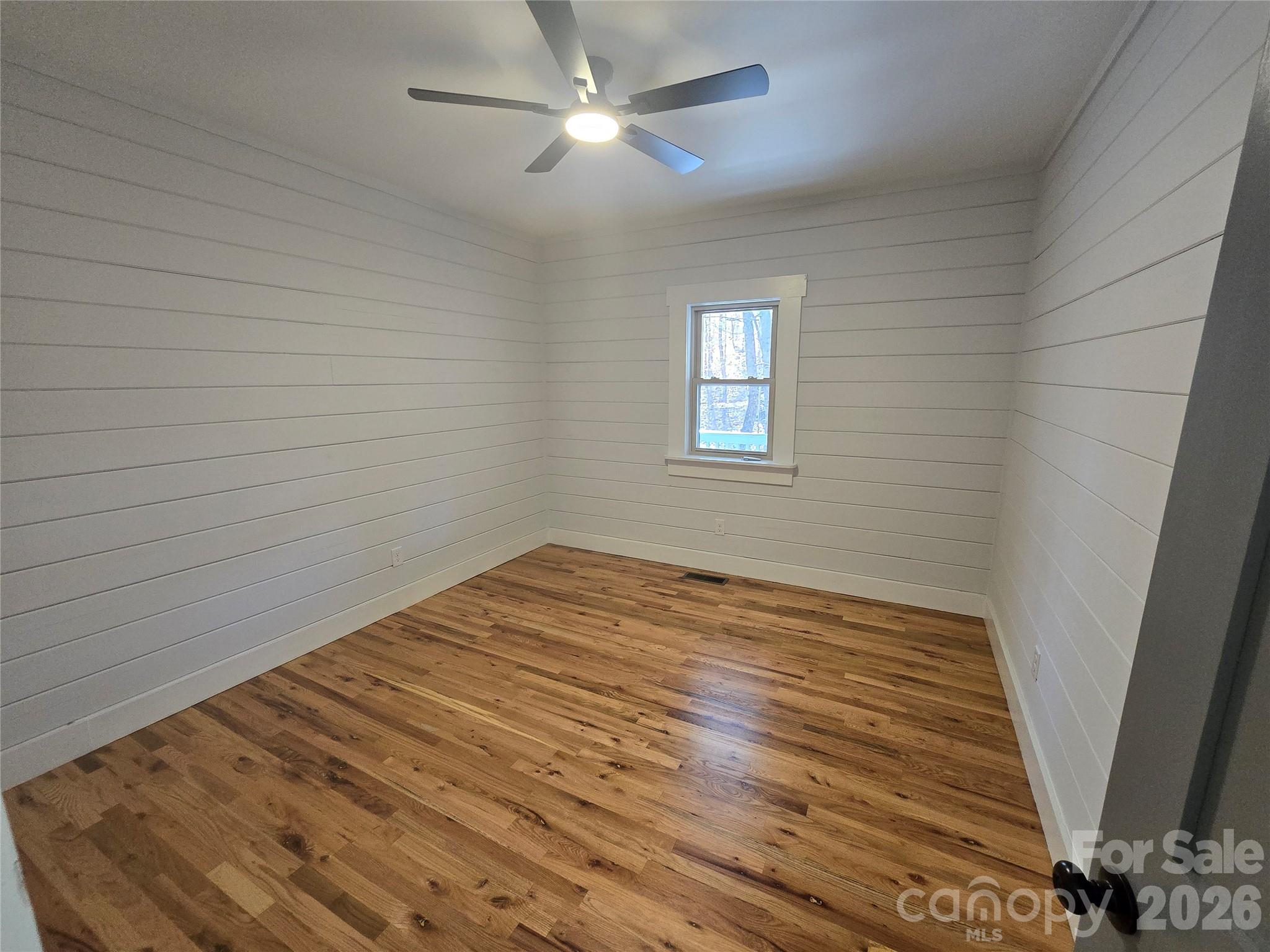 6802 Lowesville Lane Stanley, NC 28164 - Photo 21 of 25 a view of empty room with wooden floor and fan