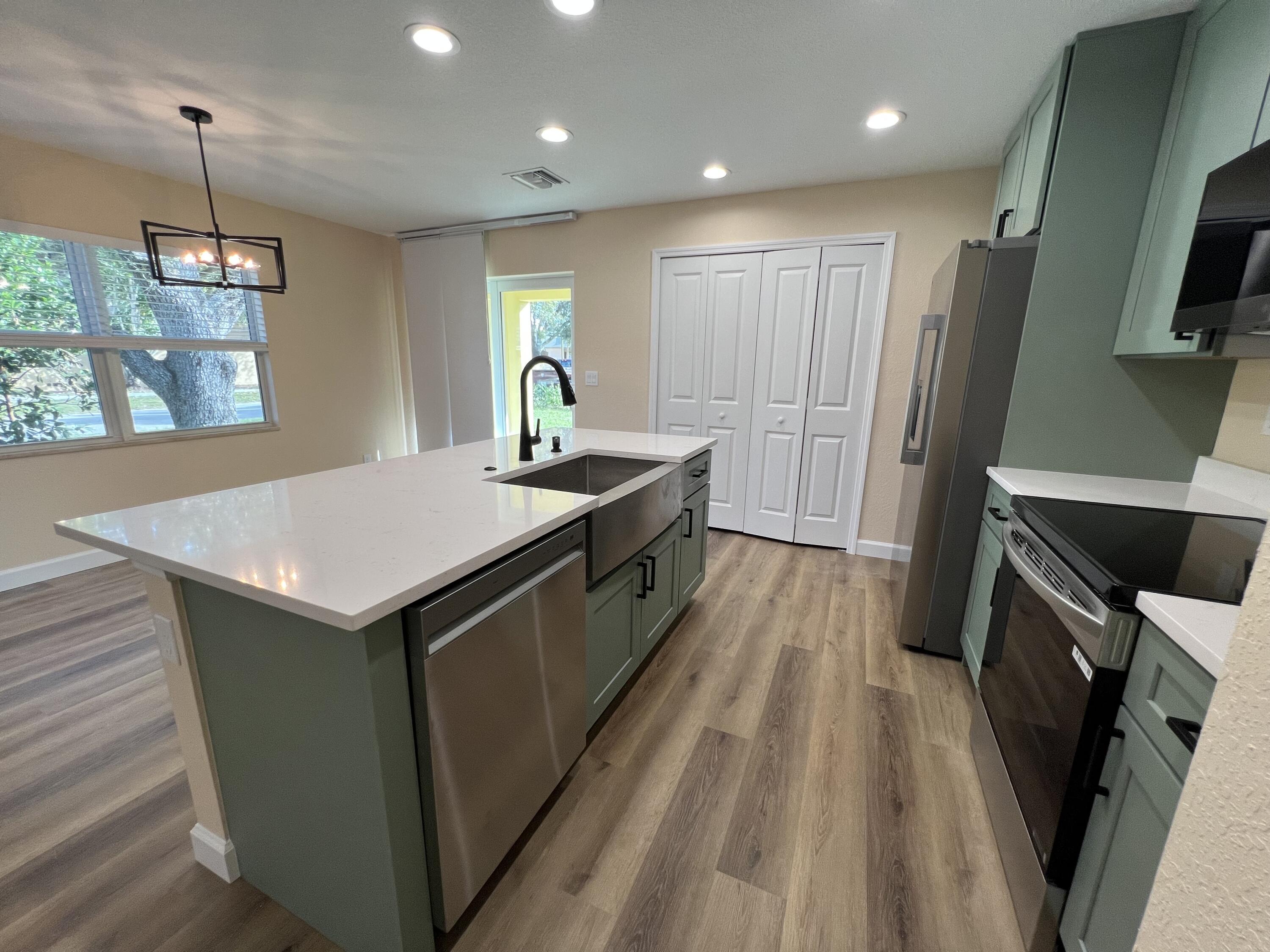 1001 Tennessee Avenue, Unit A Fort Pierce, FL 34950 - Photo 5 of 11 a kitchen with kitchen island a sink stove and wooden floor