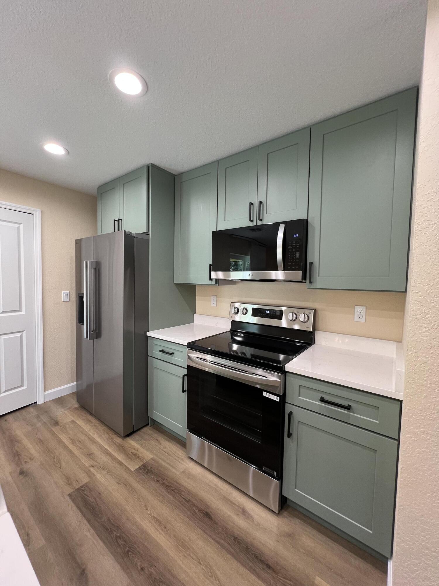 1001 Tennessee Avenue, Unit A Fort Pierce, FL 34950 - Photo 6 of 11 a kitchen with a refrigerator stove and microwave