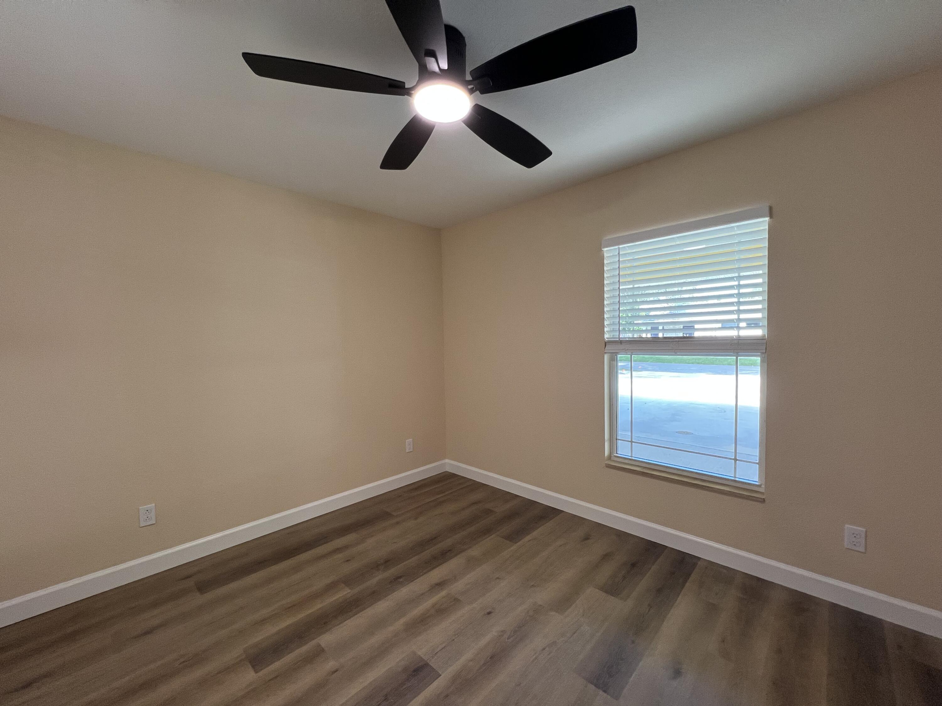 1001 Tennessee Avenue, Unit A Fort Pierce, FL 34950 - Photo 7 of 11 an empty room with a window and ceiling fan