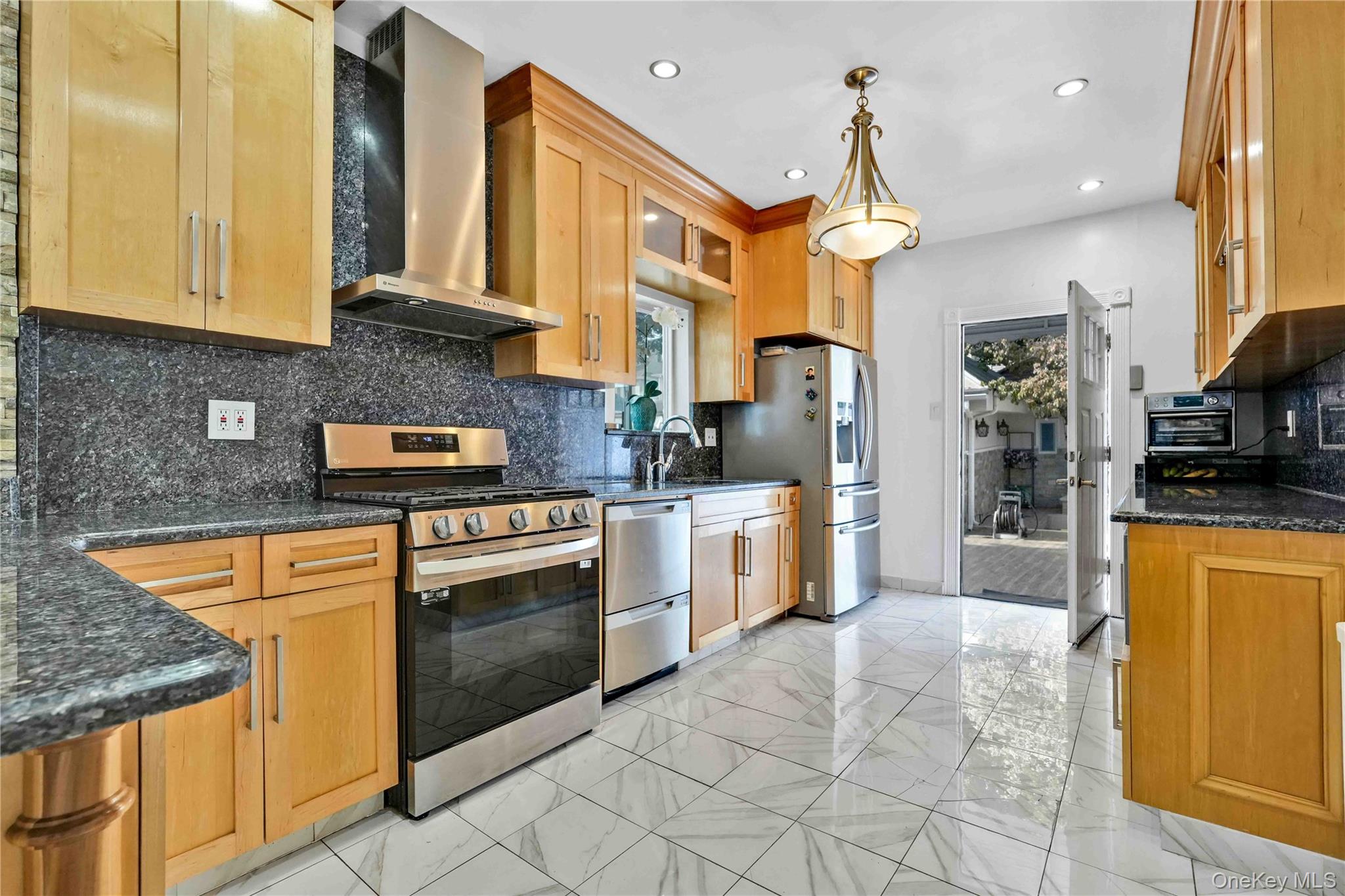 80-63 87th Road Queens, NY 11421 - Photo 12 of 37 a kitchen with stainless steel appliances granite countertop a stove a sink and a refrigerator