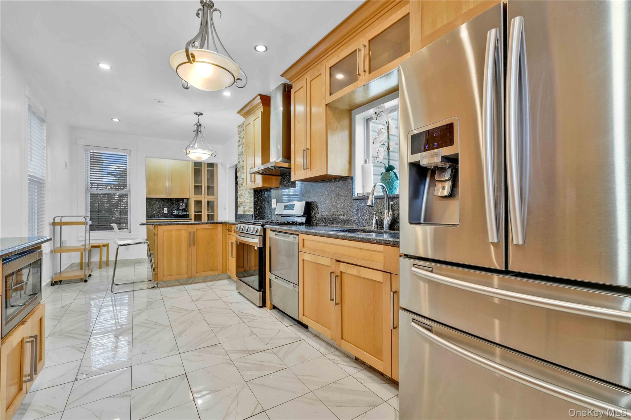 80-63 87th Road Queens, NY 11421 - Photo 9 of 37 a large kitchen with stainless steel appliances granite countertop a refrigerator and a stove top oven