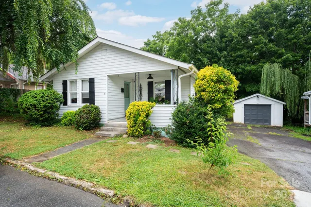 a front view of a house with a yard and potted plants