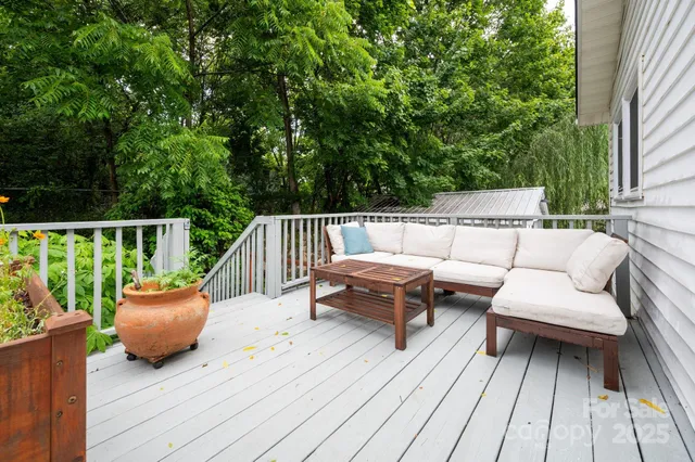 a balcony with wooden floor and outdoor seating