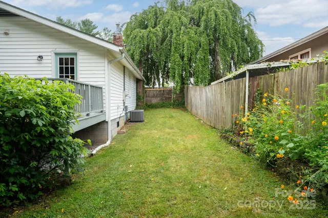 a backyard of a house with plants and tree