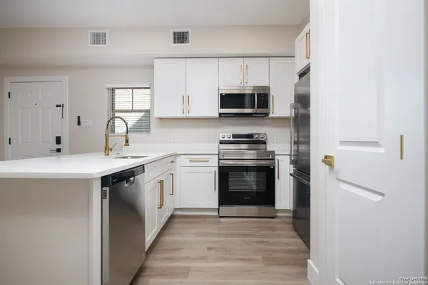 a kitchen with stainless steel appliances granite countertop a sink and a stove