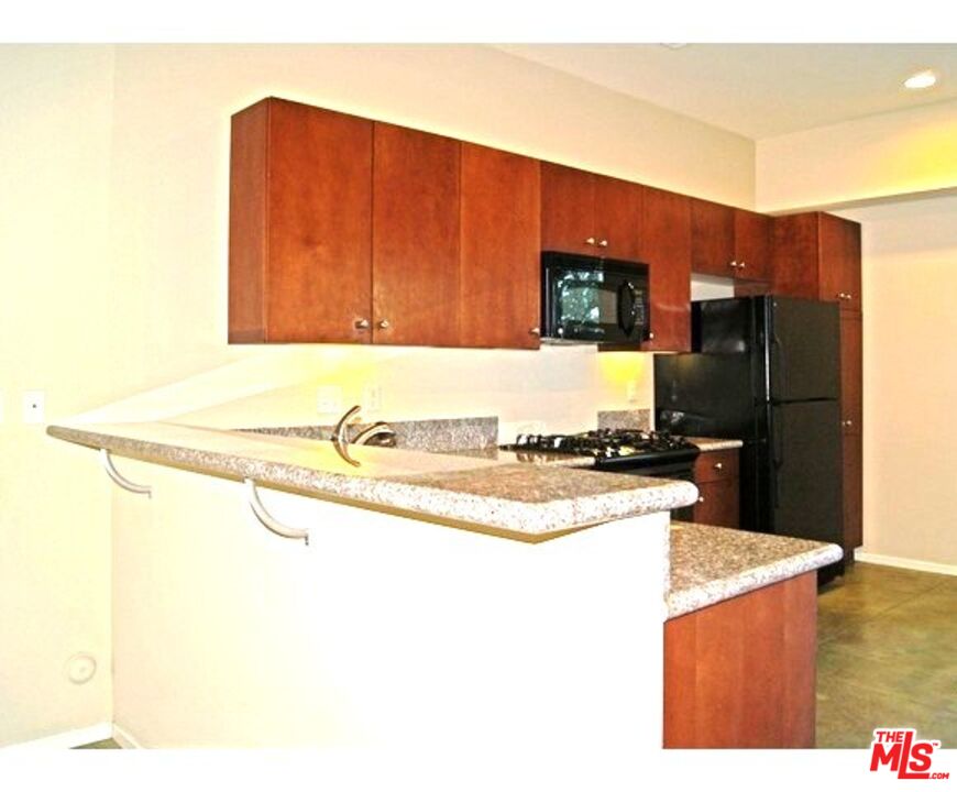 228 Sandy Point Trail Palm Springs, CA 92262 - Photo 10 of 12 a kitchen with stainless steel appliances granite countertop a sink refrigerator and microwave