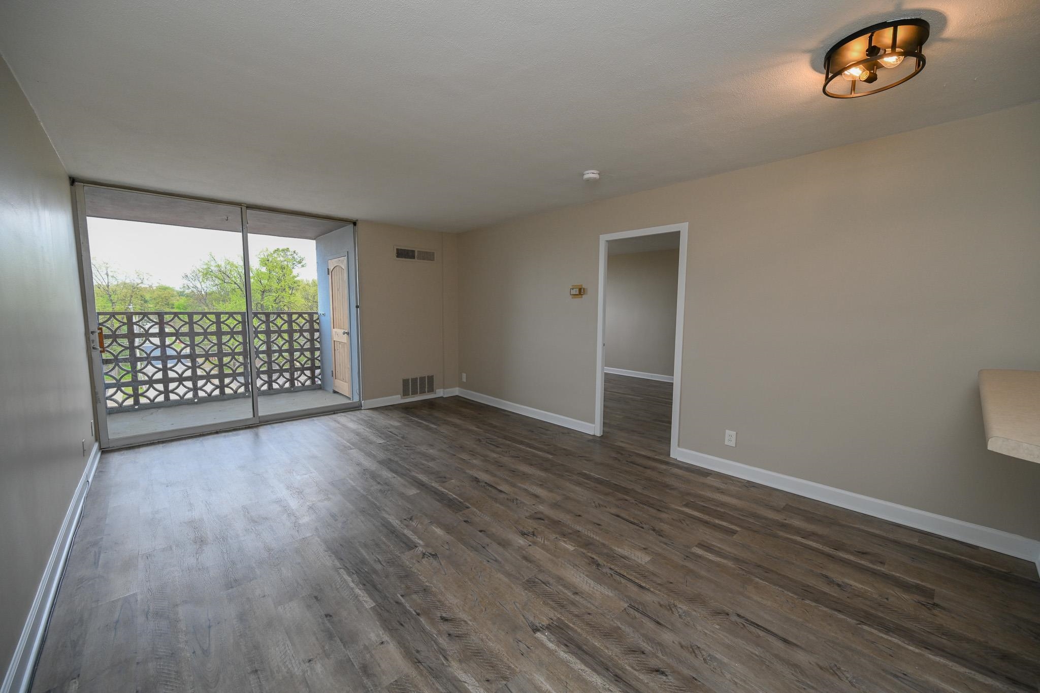 2277 Union Avenue, Unit 408 Memphis, TN 38104 - Photo 2 of 31 an empty room with wooden floor and windows