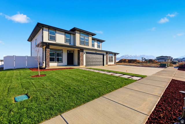 3902 West 825 North West Point, UT 84015 - Photo 5 of 49 Grass Virtually Added - View of front of property featuring a garage, covered porch, driveway, and a mountain view