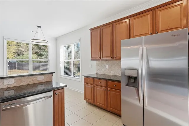 a kitchen with stainless steel appliances granite countertop a stove a sink and a refrigerator