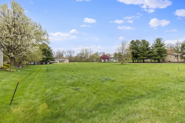 a backyard of a house with lots of green space and lake view