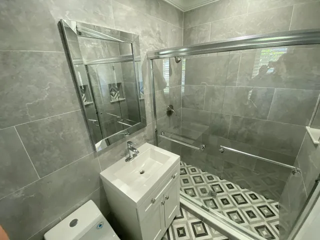 a bathroom with a sink a toilet and shower