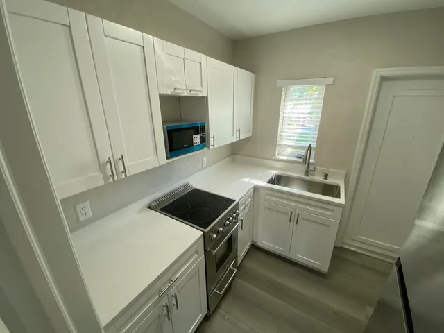 a kitchen with white cabinets and white appliances