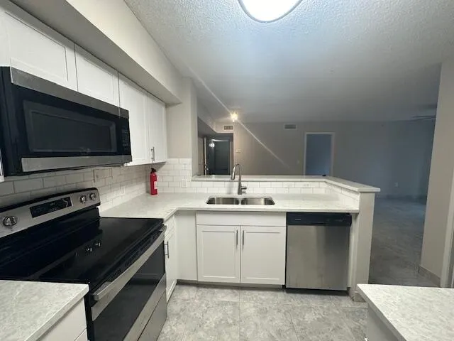 a view of a kitchen with a sink and refrigerator