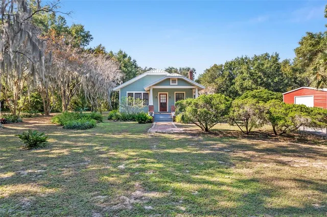 a view of an empty room with wooden floor fireplace and a window
