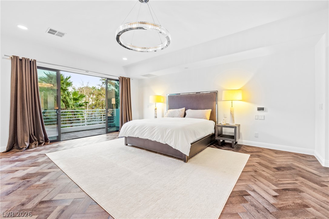 2000 Grouse Street Las Vegas, NV 89134 - Photo 41 of 89 Herringbone hardwood floors complement the elegant circular chandelier and balcony access in this luminous bedroom.