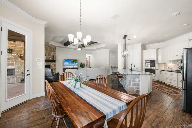 a dining room filled chandelier and wooden floor