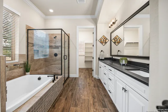 a large white bathroom with a granite countertop tub a sink and a large mirror