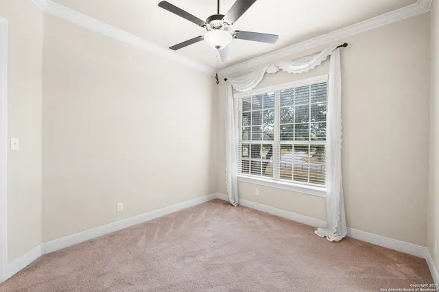 an empty room with a ceiling fan and windows