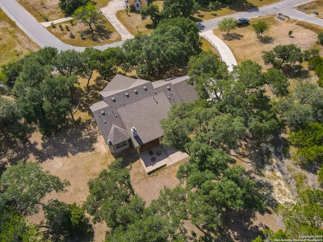 an aerial view of a house with a yard and lake view