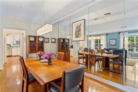 a dining room with wooden floor and large window
