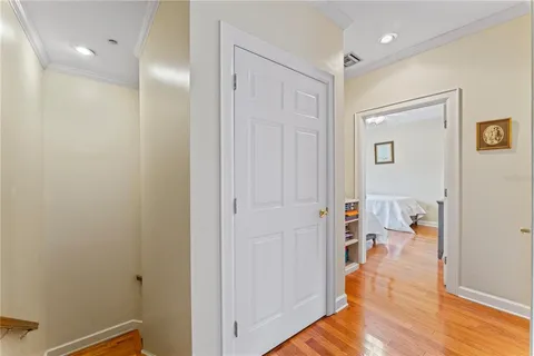 a view of a hallway with bathroom and wooden floor