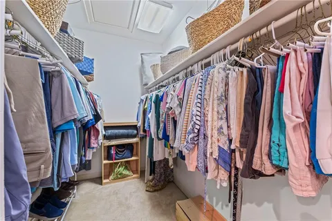 a view of walk in closet with clothes