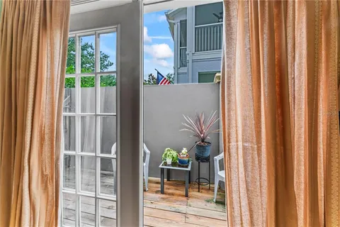 a view of a balcony with a potted plants and floor to ceiling window