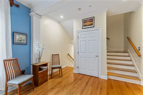 a view of a hallway with wooden floor and furniture