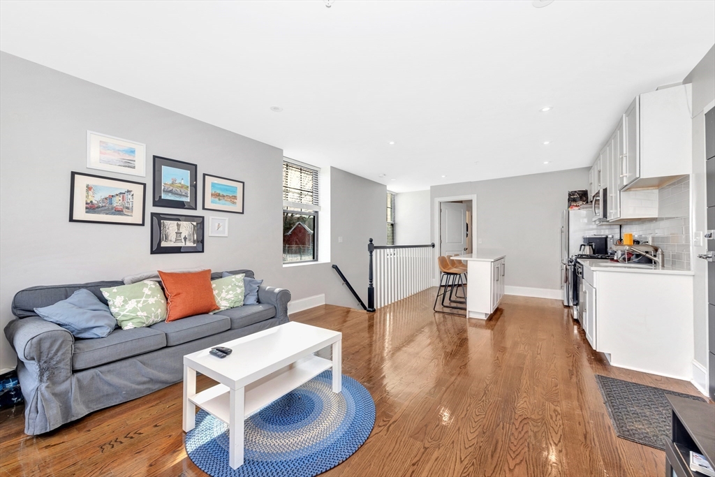 27 Dudley Street Boston, MA 02119 - Photo 34 of 42 a living room with furniture and a dining table with wooden floor