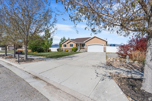 444 South Saddle Road Grantsville, UT 84029 - Photo 2 of 33 Ranch-style residence featuring a stucco exterior, attached two-car garage, and a concrete driveway