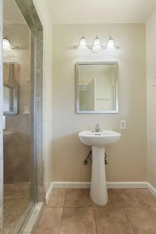a bathroom with a sink a mirror and shower