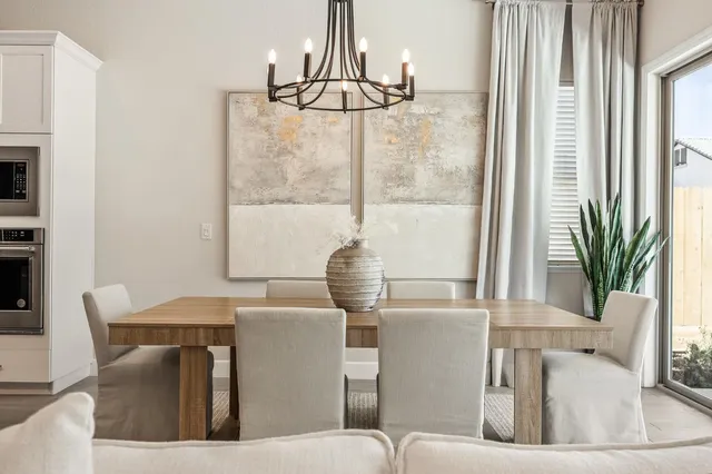 a living room with furniture a chandelier and a flat screen tv