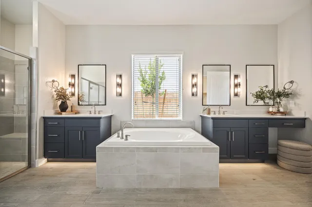 a spacious bathroom with a tub sink and mirror