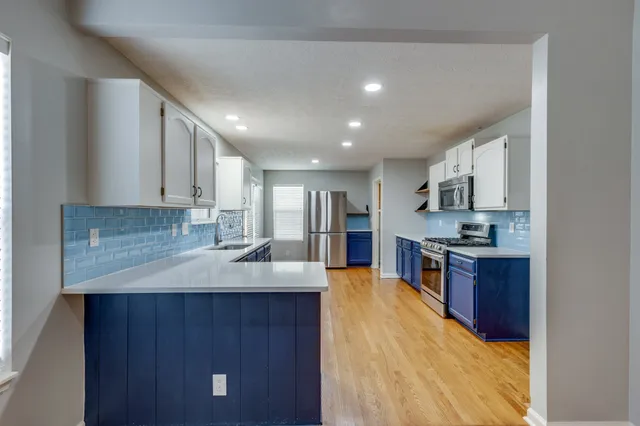 a large kitchen with kitchen island a sink stainless steel appliances and cabinets