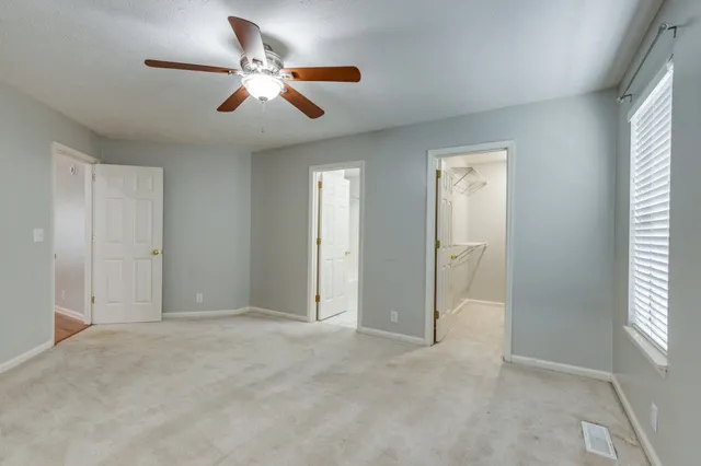 an empty room with closet and windows