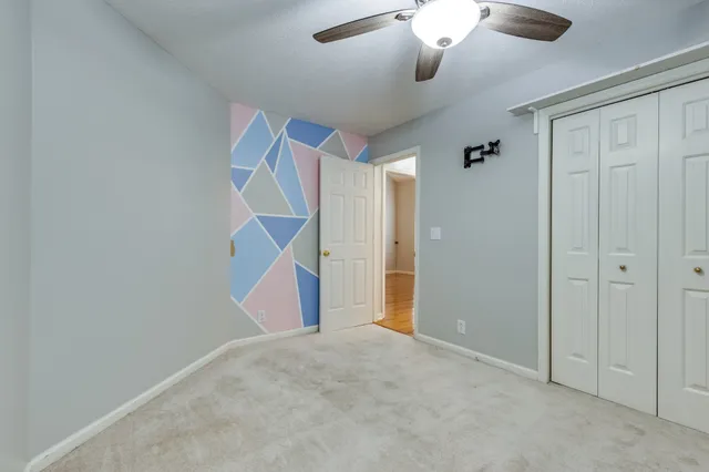 an empty room with ceiling fan and window