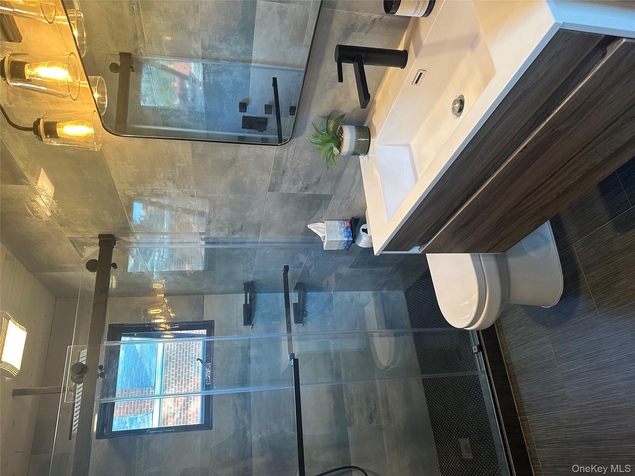 5918 Delafield Avenue Bronx, NY 10471 - Photo 22 of 31 a bathroom with a sink a toilet and shower