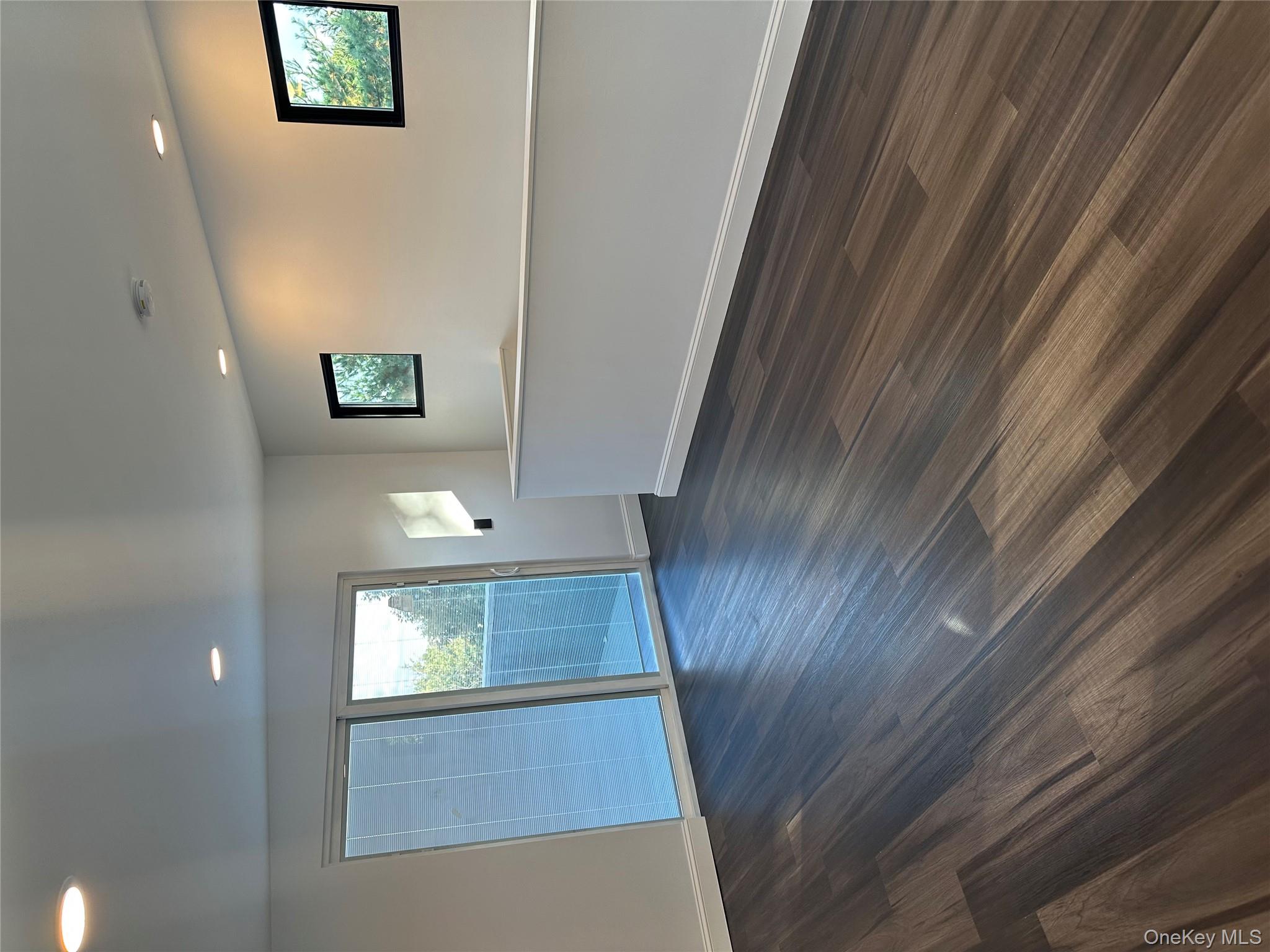 5918 Delafield Avenue Bronx, NY 10471 - Photo 26 of 31 an empty room with wooden floor and windows