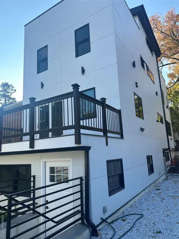 a large kitchen with stainless steel appliances a large counter top a sink a refrigerator and a window