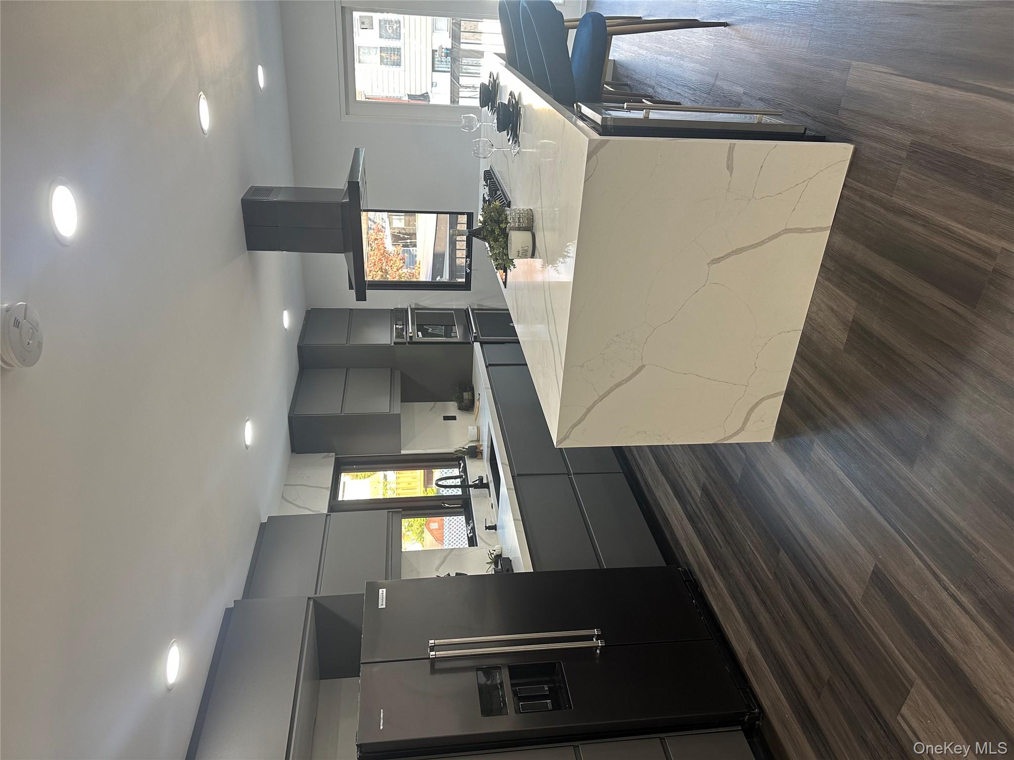 5918 Delafield Avenue Bronx, NY 10471 - Photo 7 of 31 a large kitchen with stainless steel appliances a large counter top a sink a refrigerator and a window