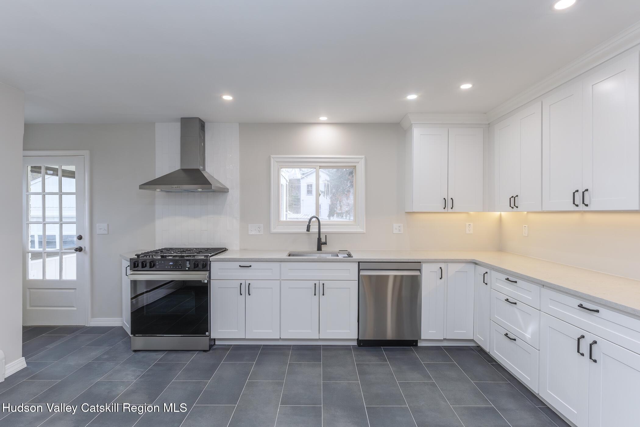 64 1st Avenue Kingston, NY 12401 - Photo 13 of 37 a kitchen with granite countertop white cabinets and appliances