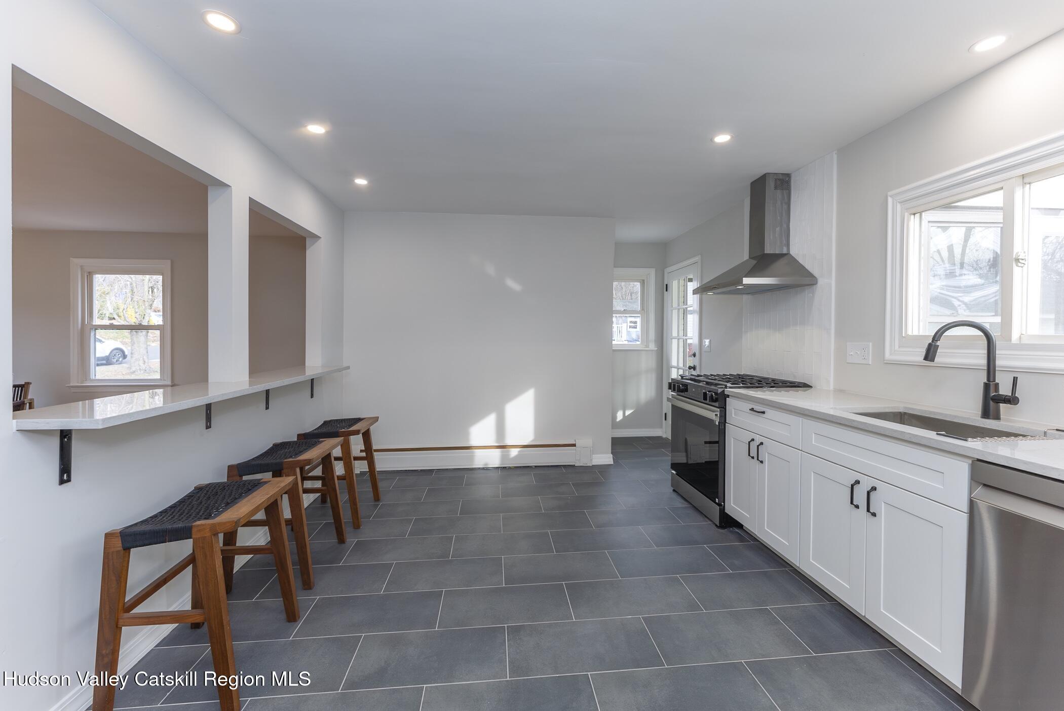 64 1st Avenue Kingston, NY 12401 - Photo 14 of 37 a large kitchen with stainless steel appliances a sink and cabinets