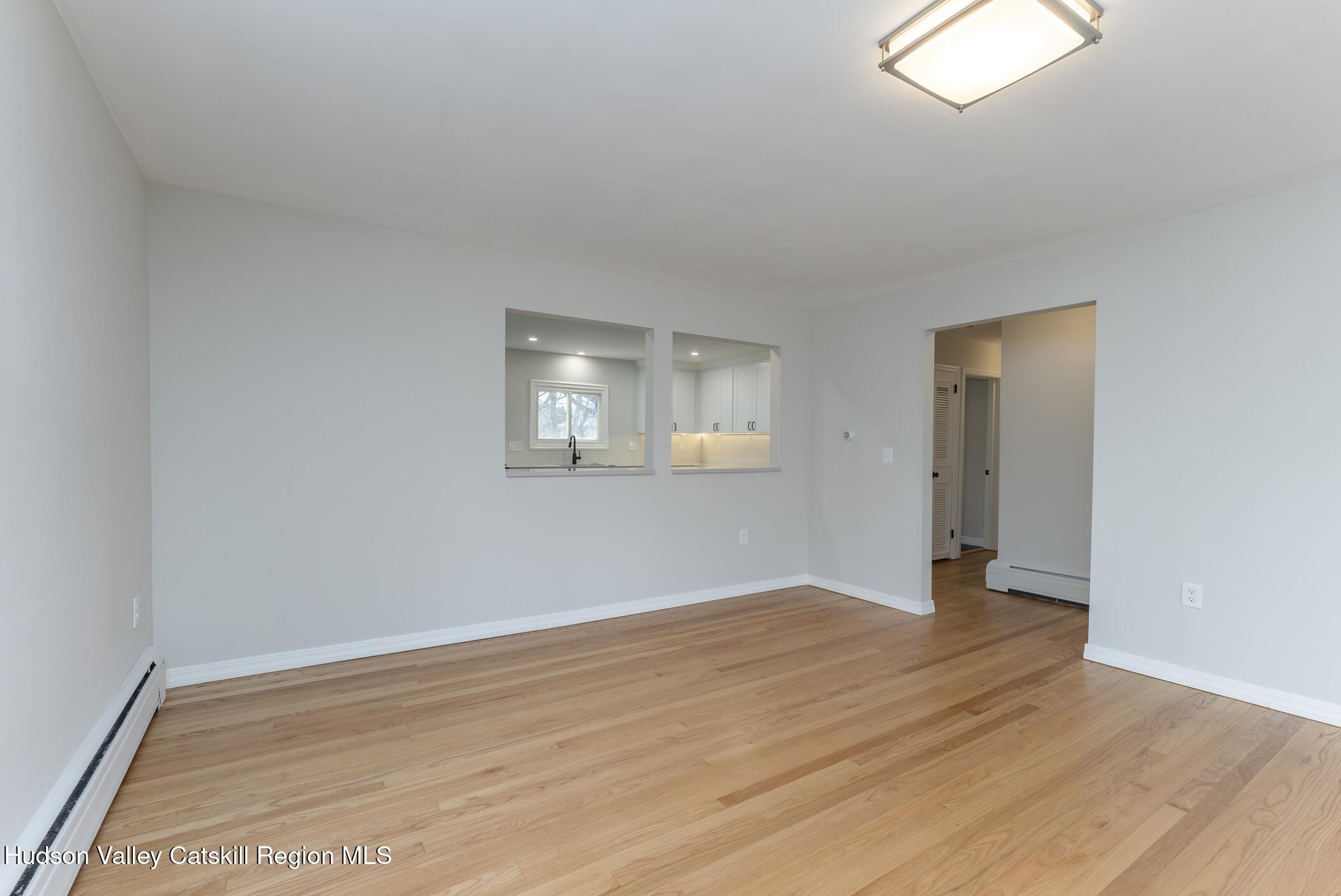 64 1st Avenue Kingston, NY 12401 - Photo 8 of 37 an empty room with wooden floor and windows