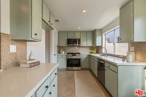 a kitchen with granite countertop a stove top oven sink and cabinets